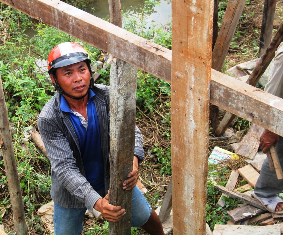 Dựng lều, che bạt ven Quốc lộ 1, thâu đêm bán mai Tết - 4 Trong khi đó, công việc dựng giàn giáo trên Quốc 1 cũng cần đòi hỏi những người thợ có tay nghề cứng trong lĩnh vực xây dựng. Bởi nền đất bùn lún, phải dùng ván gỗ lót phía dưới, rồi mới dựng giàn giáo, sau đó giằng buộc chắc chắn.