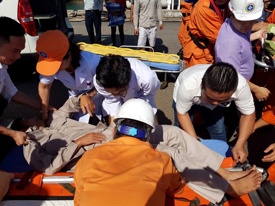 Vượt 400km, 2 ngư dân ốm nặng trên biển đã cập bờ an toàn - 2 Ngư dân Lê Thanh Chín được đưa qua cán để đưa lên xe cấp cứu