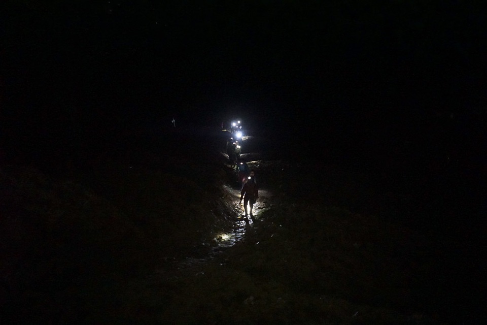 Đêm trắng ở vùng rốn quặng miền biên ải - 2 
Tận dụng điều này, người dân tộc thiểu số quanh khu vực rủ nhau đi mót quặng vào buổi đêm vì ban ngày đã bị cấm. Để vào được bãi thải (thuộc Công ty CP cơ khí và khoáng sản Hà Giang) phải đi xuống một sườn núi, qua suối, rồi ngược lên vách dựng đứng của bãi thải để mót quặng. Trong ảnh là đoàn người bắt đầu đeo đèn tiến về bãi thải khi màn đêm đổ xuống miền biên ải này.