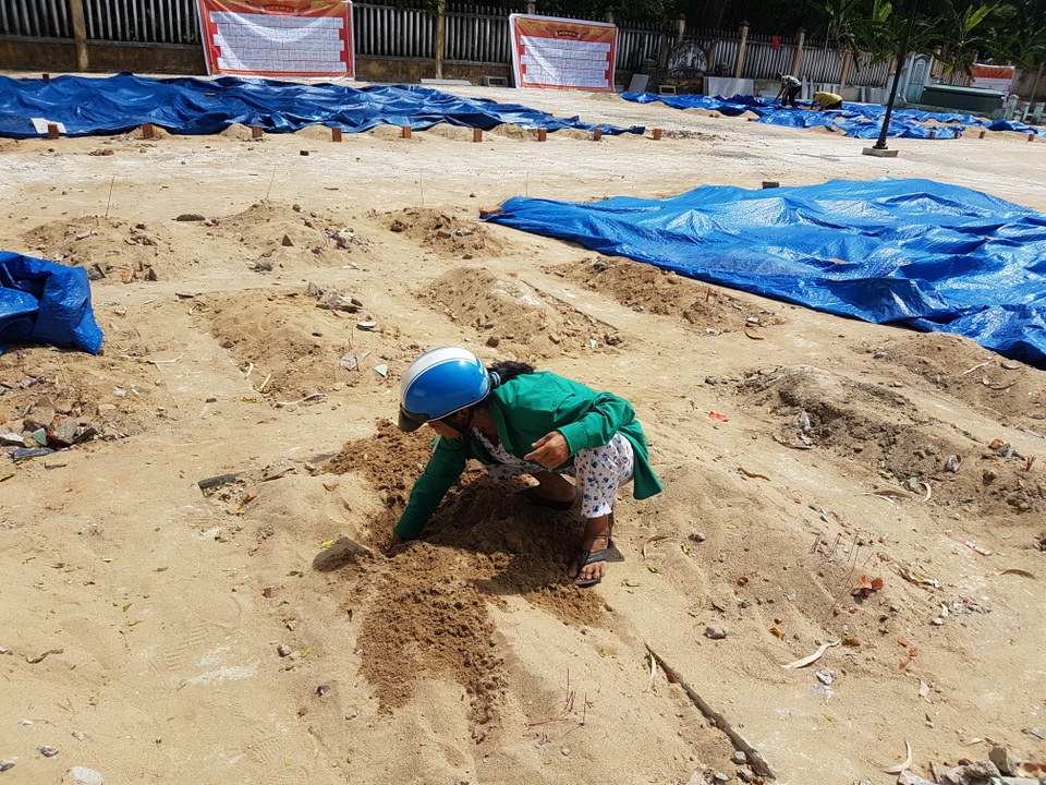 Cải tạo nghĩa trang liệt sĩ bằng cách… san phẳng phần mộ - 2 Bà Thùy đang kiểm tra phần hài cốt của thân nhân sau khi phần mộ ở trên bị san phẳng