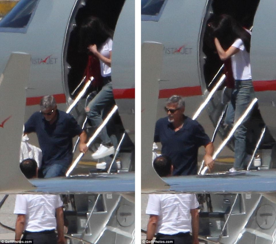 George Clooney và vợ. George chịu trách nhiệm lần lượt xách từng chiếc nôi xuống máy bay.