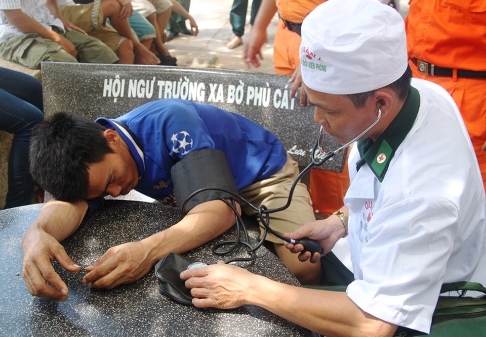 Ngư dân kể chuyện cứu 10 thuyền viên trên con tàu chìm - 5 Một thuyền viên mệt mỏi và được bác sĩ thăm khám khi vừa cập bờ