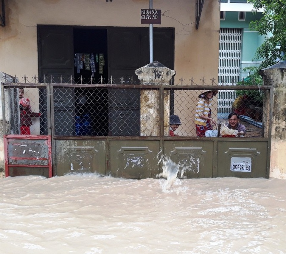 Bão vừa qua, người dân lại gồng mình chống chọi với lũ - 8 Người dân ngăn nước, tát nước ra khỏi nhà