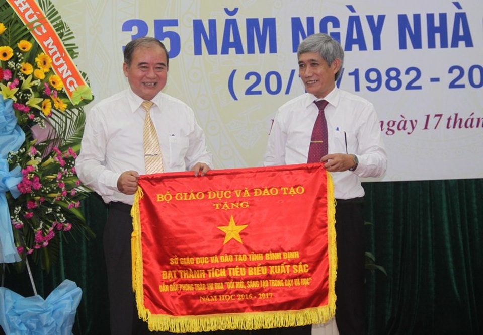 Ông Đào Đức Tuấn (trái), Giám độc Sở GD-ĐT Bình Định đại diện cho Sở nhận Cờ thi đua của Bộ GD-ĐT vì thành tích dẫn đầu phong trào thi đua “Đổi mới, sáng tạo trong dạy và học” năm học 2016-2017.