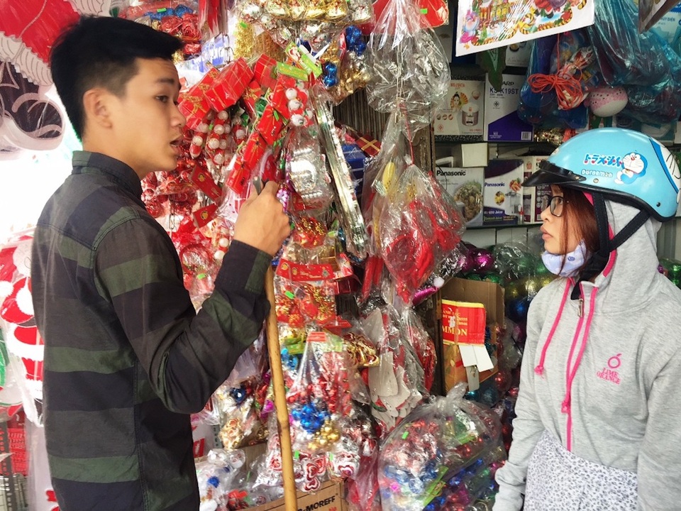 Nhập quả châu cao cấp, thông tươi từ Mỹ... về đón Giáng sinh - 2 Một nhân viên bán hàng tư vấn cho khách mua đồ trang trí Giáng sinh