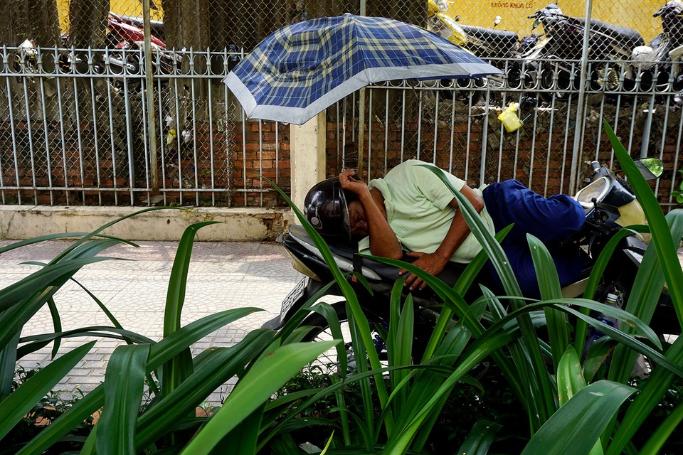 Người Sài Gòn tìm đủ cách “trốn” nóng - 11 Bác xe ôm ngủ trưa dưới chiếc dù tự chế gắn lên xe trước cổng bệnh viện Nhi Đồng 1, đường Lý Tự Trọng, quận 1.
