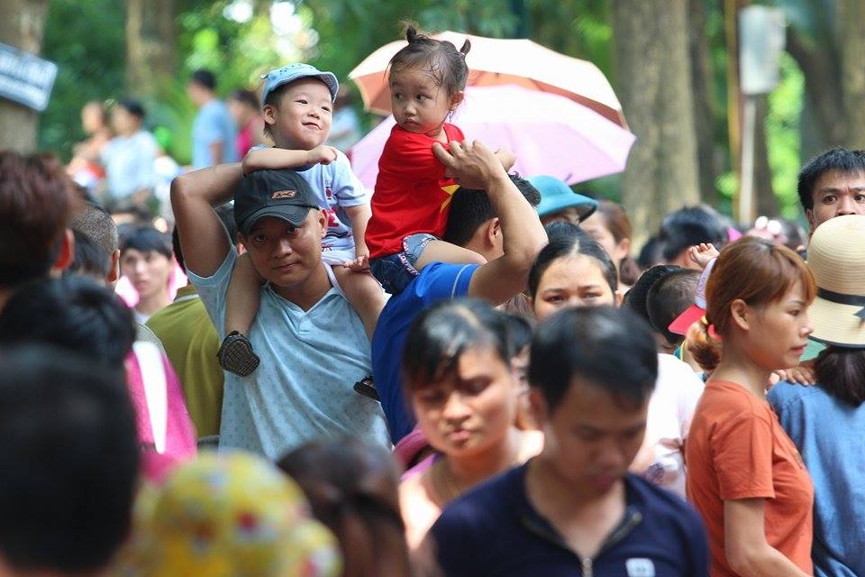 Do quá đông đúc, nhiều ông bố đành phải chọn cách bế con lên cao để dễ di chuyển trong biển người.