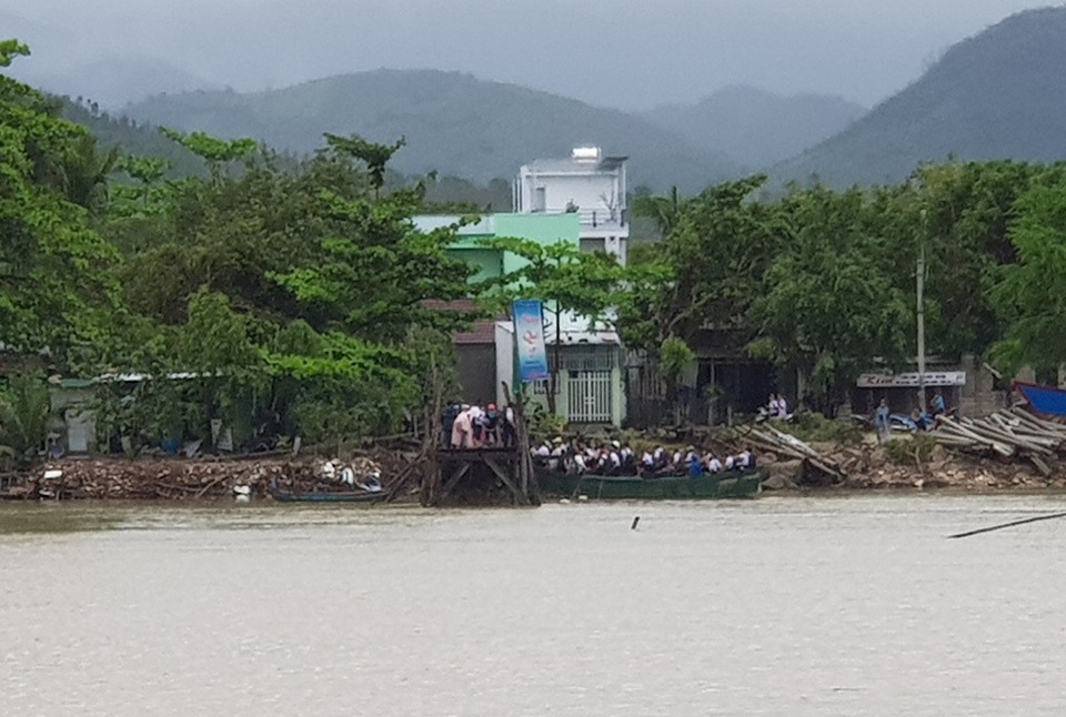Không có cầu, học sinh phải đi thuyền đến trường trong mưa gió - 2 Trong khi đó, ở bờ bắc sông Cái, hàng chục em khác lên thuyền qua sông đi học