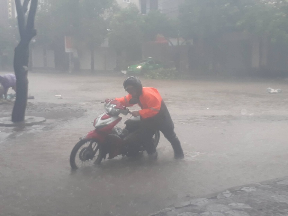 Bắc miền Trung mưa trắng trời, gió giật dữ dội trong bão - 5
Người dân di chuyển khó khăn trong mưa bão...