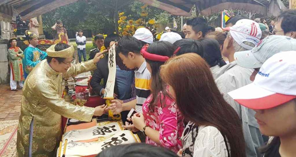 Lễ khai ấn năm mới và hạ nêu trong Hoàng cung Huế - 4 Nhiều du khách thích thú được nhận chữ quý có ấn vua đóng