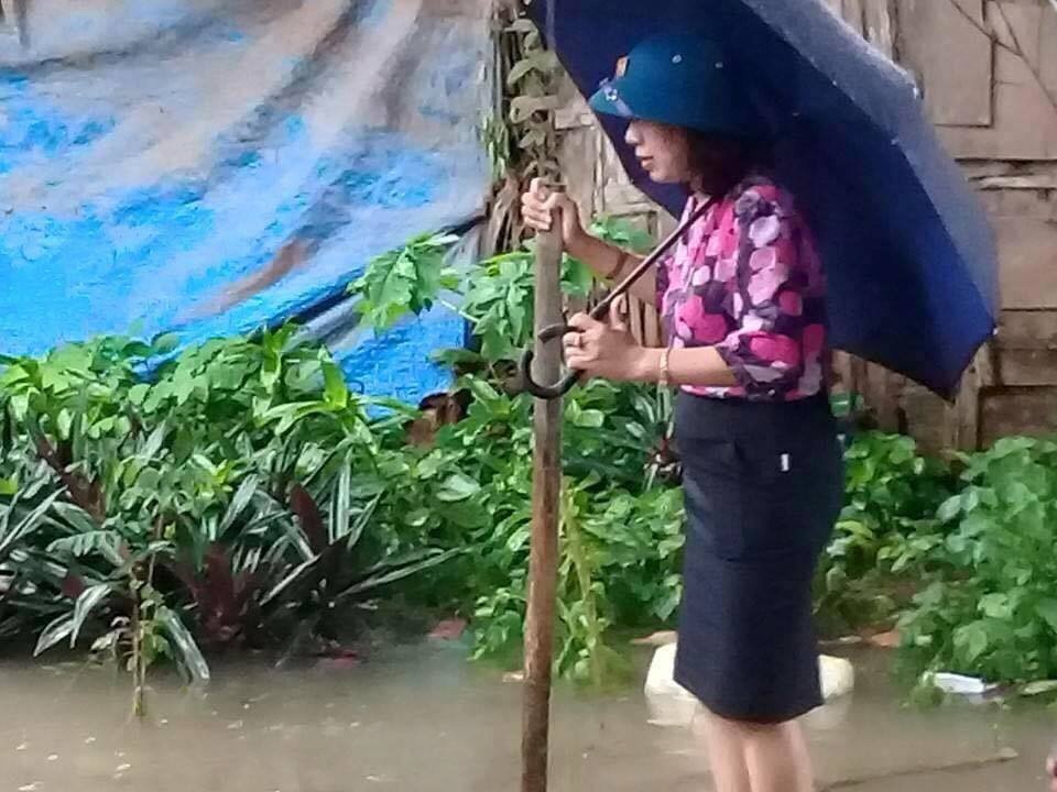 Chủ tịch phường mặc váy đứng trên bè cho người kéo qua vùng nước ngập - 2
Hình ảnh bà Tâm đứng trên bè.