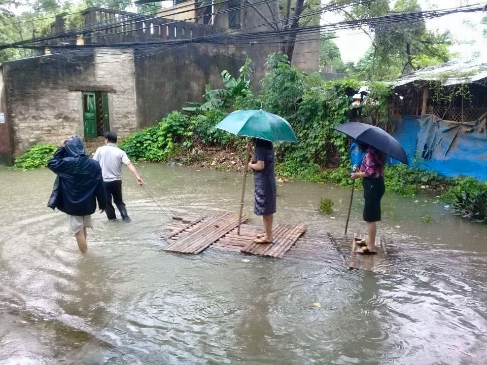 Chủ tịch phường mặc váy đứng trên bè cho người kéo qua vùng nước ngập - 1 Hình ảnh bà Tâm mặc váy đứng trên bè (phía sau) đi chống lũ gây xôn xao