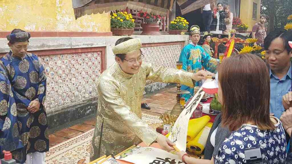 Lễ khai ấn năm mới và hạ nêu trong Hoàng cung Huế - 3 Trao tặng cho du khách các chữ được đóng ấn vua