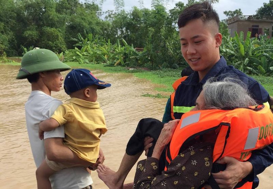 Các chiến sĩ Cảnh sát PCCC đưa người già ra khỏi vùng ngập lụt