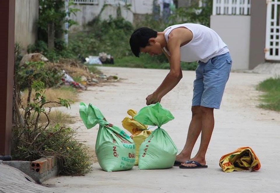 Người dân Nam Trung Bộ "thở phào" khi bão Kirogi suy yếu - 1 Người dân TP Nha Trang hối hả buộc bao cát trên đường phố để chuẩn bị đưa lên mái nhà khi có thông tin cảnh báo bão số 14