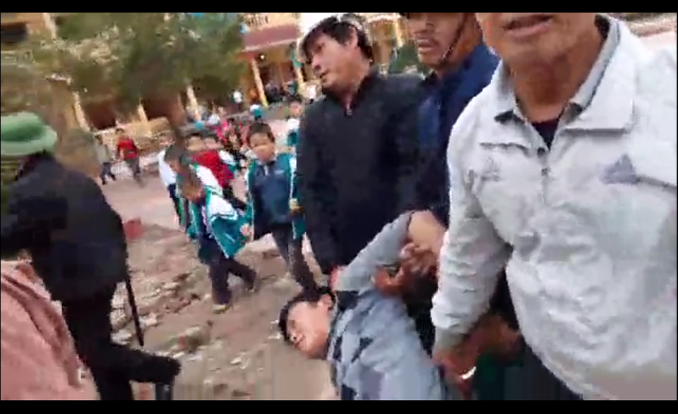Hàng trăm người “vây” trụ sở xã suốt một ngày phản đối công an bắt người - 3
Ông Cao bị khênh qua trường học (ảnh cắt từ clip)