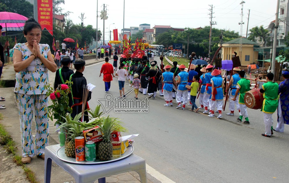 Trai Hà Nội mặc váy rước nước trên sông Hồng - 2 Một người dân cầu khấn khi đoàn rước kiệu đi qua