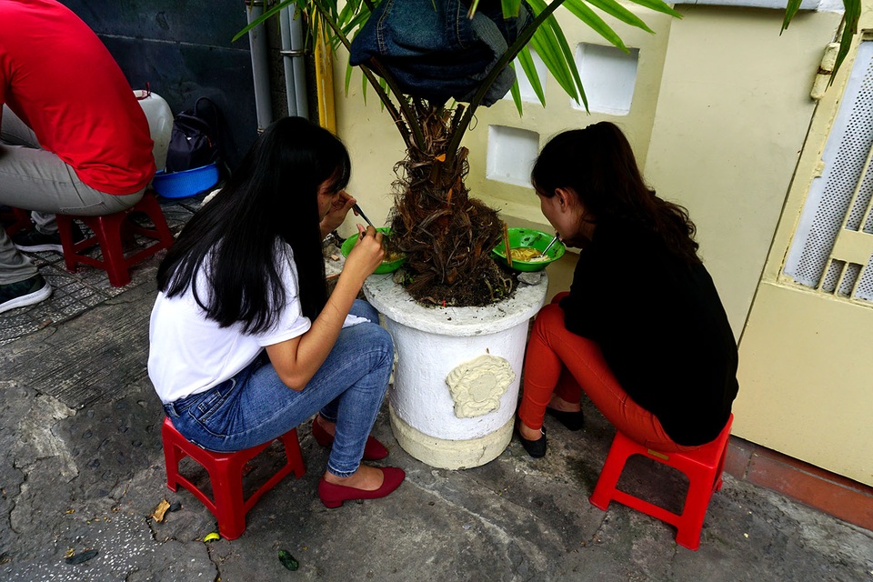 Người Sài Gòn tìm đủ cách “trốn” nóng - 5 Hai cô gái dùng bữa trưa dưới gốc cây cảnh để tránh nắng.