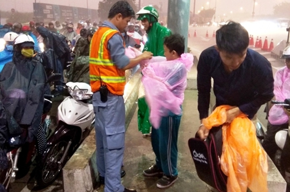 Đoàn viên thanh niên hầm Thủ Thiêm phát áo mưa miễn phí cho người dân không có áo mưa khi qua hầm Thủ Thiêm.