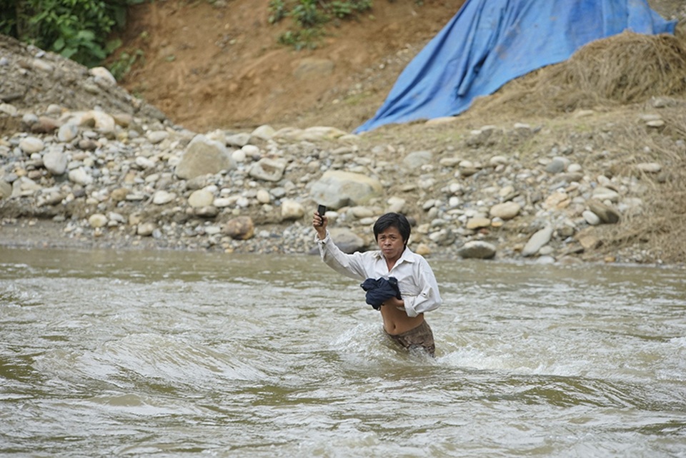 Hình ảnh người dân "đánh cược mạng sống" khi mưa lũ cuốn trôi cầu tạm - 7 
Đàn ông qua suối đã khó khăn...