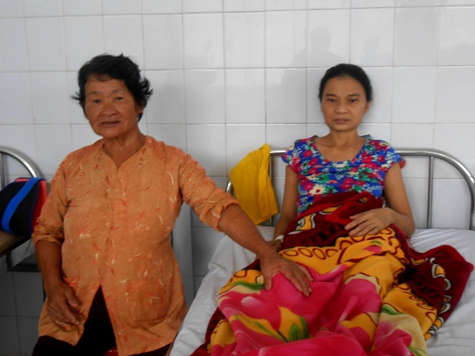 Bà Nguyễn Thị Lật luôn túc trực bên giường bệnh chăm sóc cho người hàng xóm khốn khổ