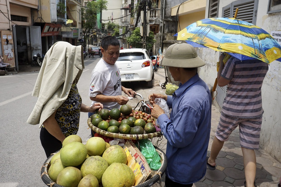 Người dân ra đường với ô hoặc bất kể thứ gì để che nắng.