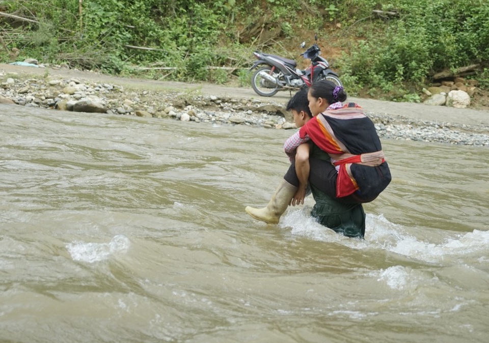 Hình ảnh người dân "đánh cược mạng sống" khi mưa lũ cuốn trôi cầu tạm - 5 
Anh Tẩn Cáu Sinh cõng vợ con sang trung tâm xã để đi khám bệnh cho con.