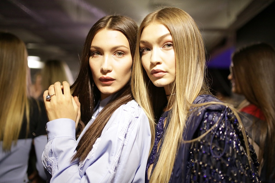 Người mẫu Bella Hadid (trái) có một gương mặt già giặn hơn cả chị gái - người mẫu Gigi Hadid (22 tuổi - phải), nhưng kỳ thực Bella mới 20 tuổi.