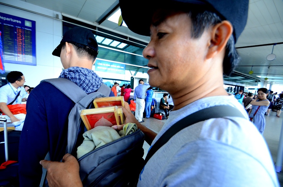 Tặng lá bồ đề cho du khách xuất hành đầu năm - 5 Du khách khá cẩn thận cất chiếc lá bồ đề vào hành lý.