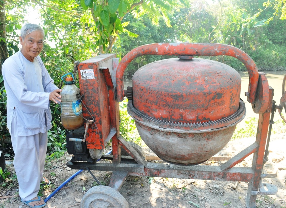 Những cụ ông 70 tuổi vác cát, bẻ sắt… xây cầu từ thiện - 4 Cụ Võ Văn Lộc cho biết, tất cả các thiết bị máy móc thi công cầu đường đều do các mạnh thường quân tài trợ. Hiện nay cái máy trộn hồ này đã bị hư, đội đang cần một cái máy mới