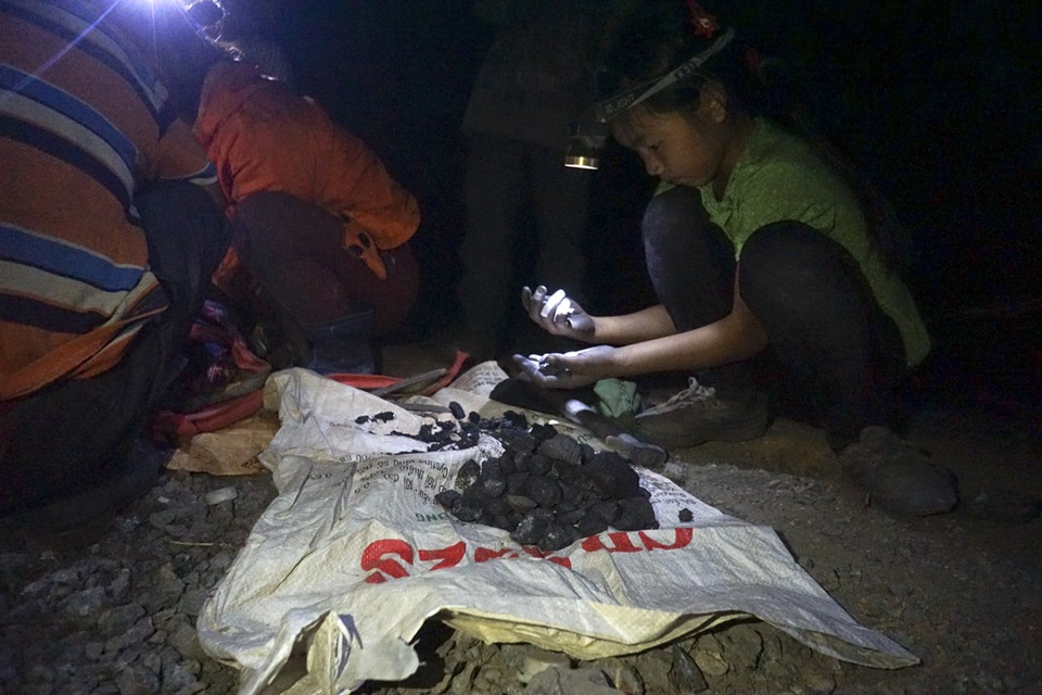 Đêm trắng ở vùng rốn quặng miền biên ải - 7 
Sau khi đào bới, soi, nhặt trên sườn bãi thải dốc đứng, những viên quặng được người dân cho vào túi hoặc bao tải và mang ra ngoài để lựa chọn lần 2 ngay trong đêm trước khi bán.