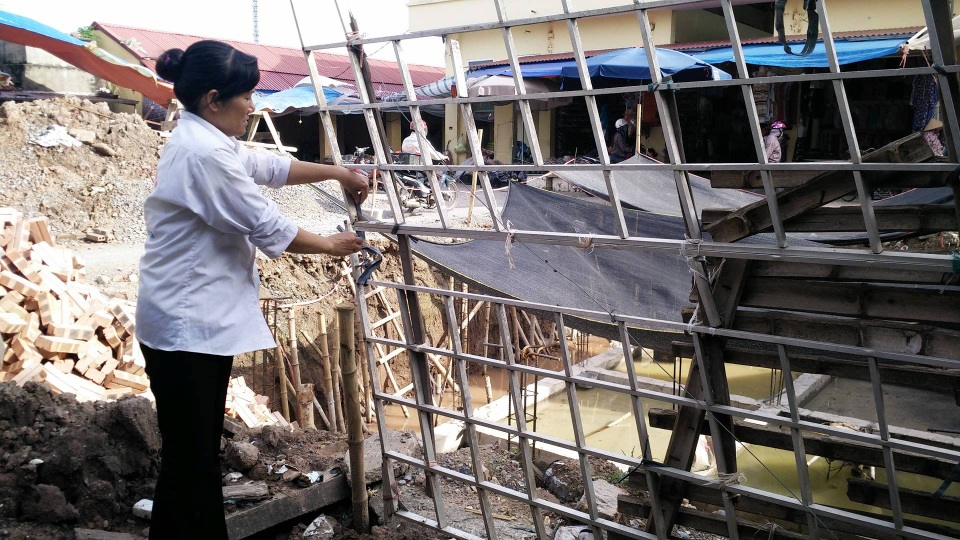 Gia đình liệt sĩ hơn chục năm tìm công lý 35m2 đất giờ ra sao? - 4 Chị Hạnh gia cố lại hàng rào tạm điểm giáp danh giữa đất của gia đình và chợ Nhạc. Nỗi lo mất đất vẫn luôn canh cánh đối với cả gia đình chị.
