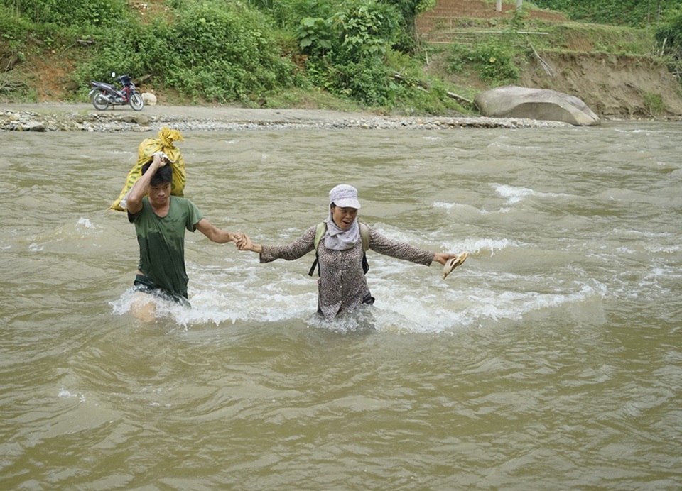 Hình ảnh người dân "đánh cược mạng sống" khi mưa lũ cuốn trôi cầu tạm - 6 
Người dân cho biết, ngày nào họ cũng lội qua suối từ 2-4 lần. Mực nước trung bình sâu khoảng 70cm, có nơi sâu 1 mét, nước chảy rất xiết và có nhiều đá trơn dưới lòng suối.