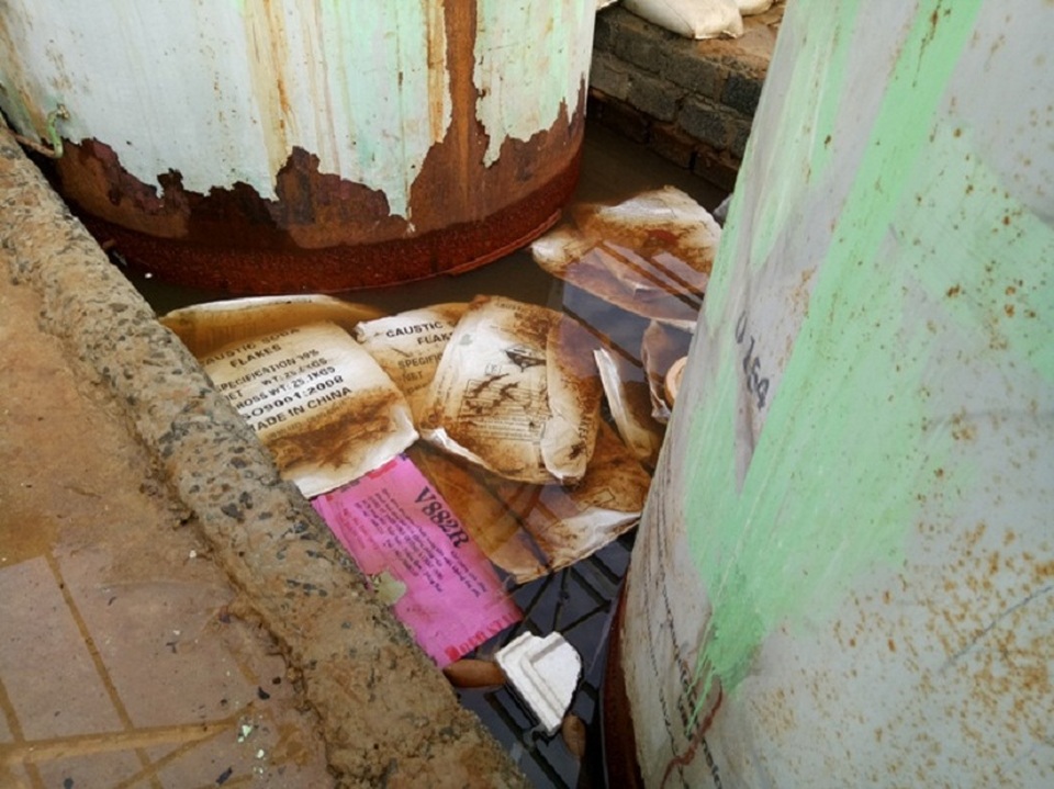 Những bao bì có chữ Caustic Soda Flakes và Made in China vương vãi trong nhà kho