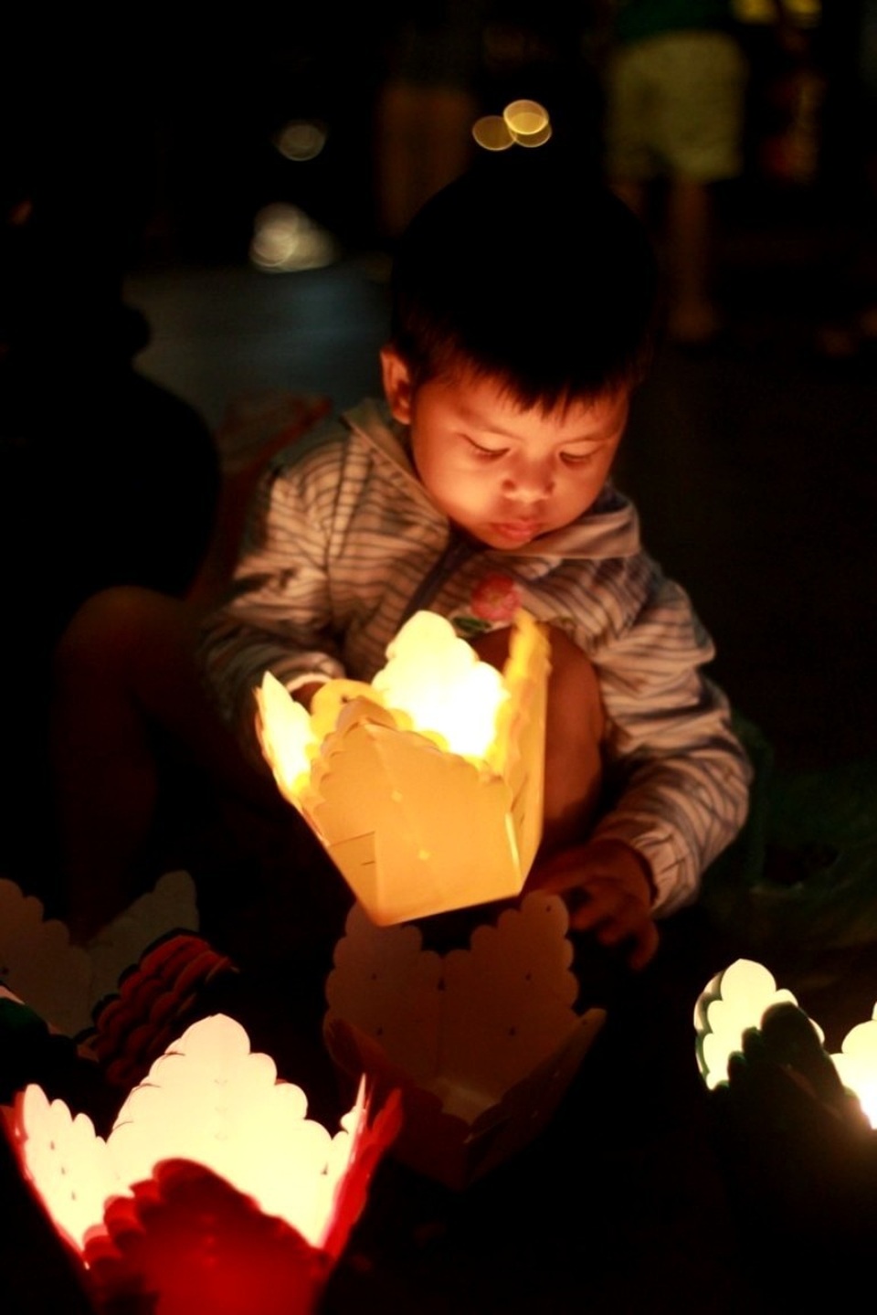 Cậu bé Bi cùng mẹ bán hoa đăng cho khách trong đêm giao thừa 31/12 cười vui vẻ: “Con mong năm mới con sẽ cao thêm, có nhiều đồ chơi hơn nữa. Và mẹ con bán được thật nhiều hoa đăng có thêm tiền mua bánh, đồ ăn ngon cho con nữa”