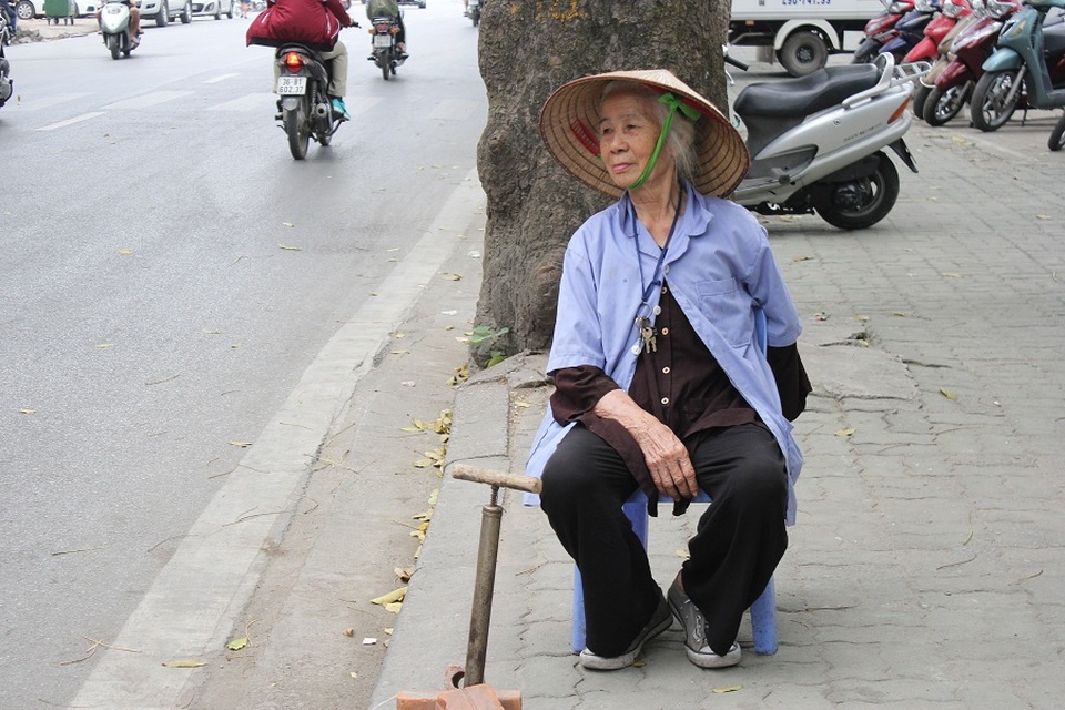 Dù mưa hay nắng, cụ Vân vẫn đều đặn xách đồ nghề mưu sinh bằng công việc bơm vá xe bên góc đường Đê La Thành. (Ảnh: Hà Trang)