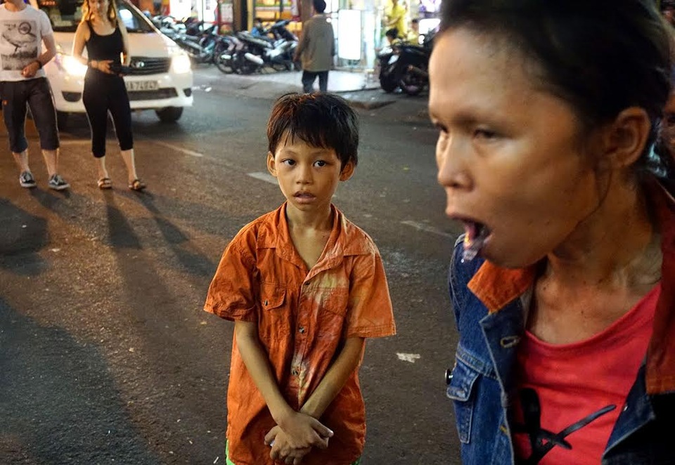 Người phụ nữ ngậm dầu phun lửa hàng đêm, nuôi hai con ăn học - 7 Cậu con trai út luôn theo mẹ mỗi đêm diễn, vừa phụ mẹ mang đồ nghề, vừa hỗ trợ mỗi khi chị Sen bị thương.