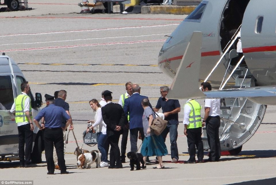 Một nhóm người đứng chờ sẵn trên sân bay để giúp gia đình Clooney di chuyển.