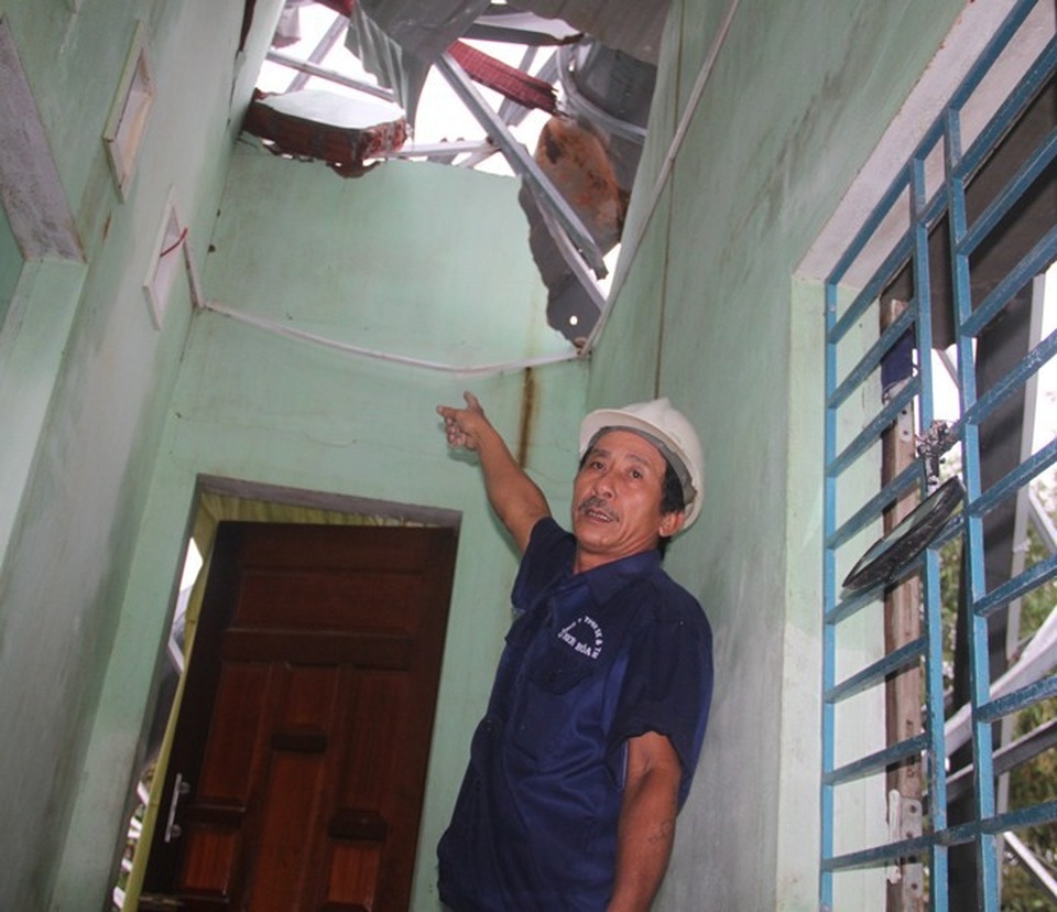 Ông Khương chỉ tay vào chỗ tường sập vì trụ pano quảng cáo nặng hàng tấn đổ đè vào nhà ông.