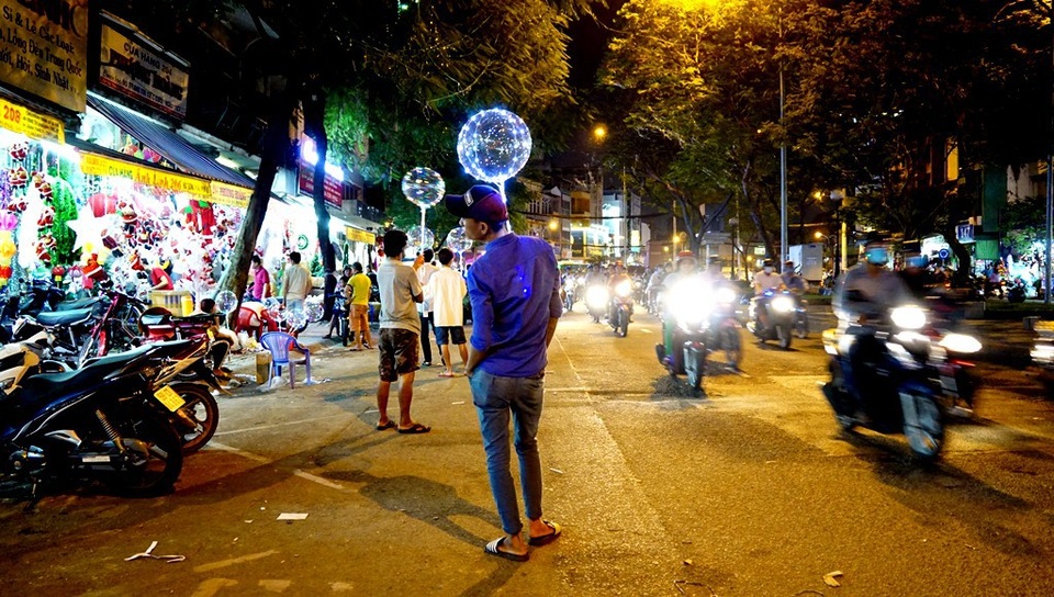 Bán chậm, cầm trên tay một lúc cũng chán, nhân viên này vắt luôn bong bóng đèn vào cổ áo…