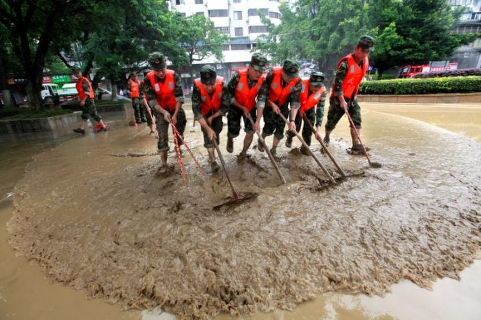 Lũ lụt kinh hoàng ở Trung Quốc, ít nhất hơn 30 người thiệt mạng - 8 Cảnh sát dọn dẹp một con đường bị ngập ở tỉnh Quý Châu hôm 30/6. (Ảnh: Reuters)