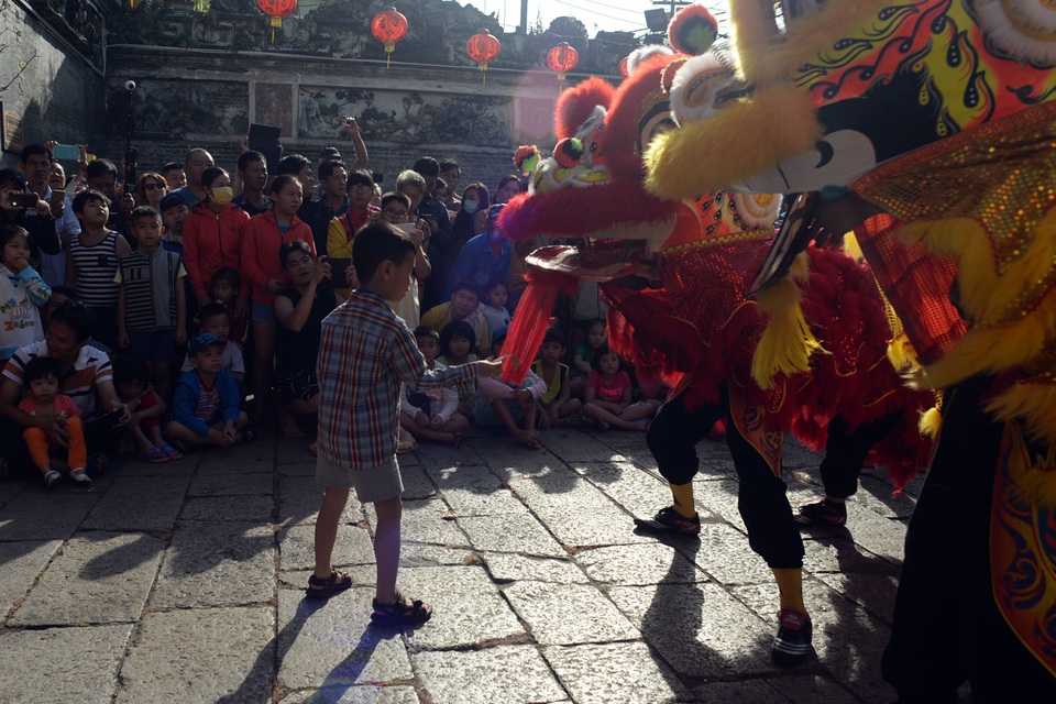 Lân sư rồng "nghinh tiếp" Đinh Dậu - 7 Cuối năm là dịp để các đoàn lân sư rồng kiếm tiền lì xì của mọi người. Một cậu bé chạy ra lì xì cho đoàn lân sư rồng đang biểu diễn.