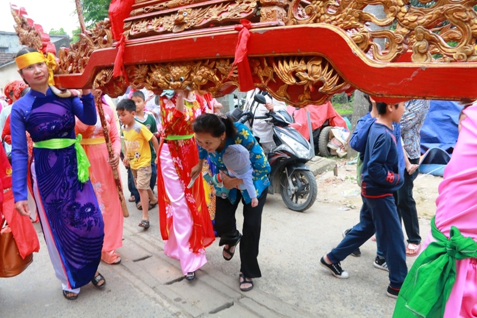 Một em bé chưa đầy 1 tuổi được bà bế cùng chui kiệu cầu bình an. Đa số, những người chui kiệu là phụ nữ và trẻ em, thi thoảng có một vài nam thanh niên hay những người trung tuổi khác.