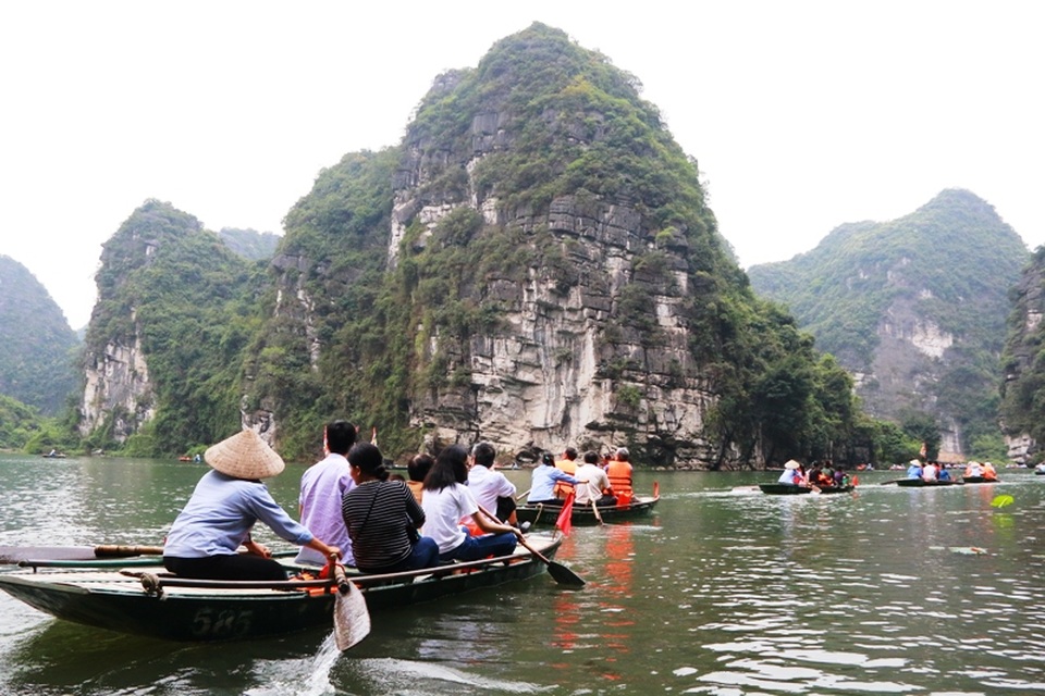 Du khách ngồi thuyền khám phá vịnh Hạ Long trên cạn ở Ninh Bình.