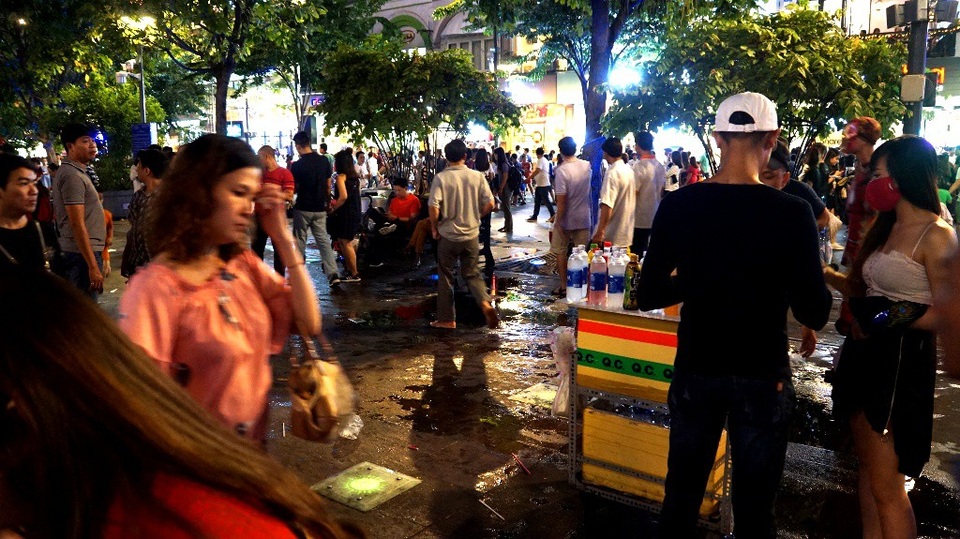 Phố đi bộ Nguyễn Huệ nhếch nhác vì... rác, hàng rong - 9 Nước chảy ra từ một hàng bán nước giải khát, nhiều du khách qua lại, giẫm chân lên kéo nước lan rộng nhìn con đường rất mất mỹ quan