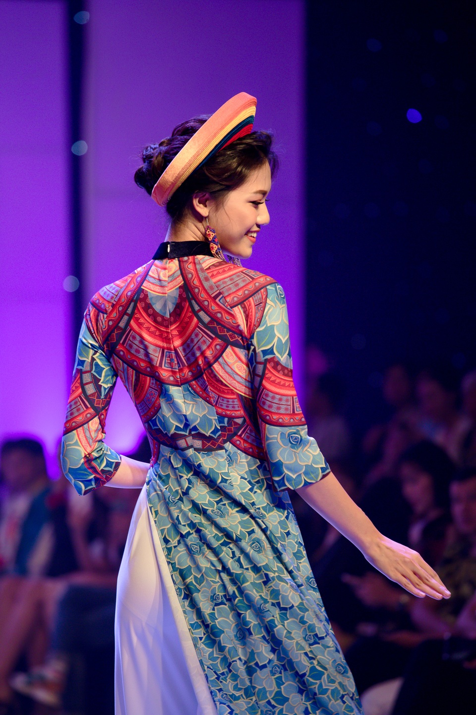 Tiếp theo là Á hậu 1 Thanh Tú xuất hiện trong tà áo dài với sắc xanh chủ đạo, điểm xuyến bằng những gam màu nóng ở thân trên của áo. Cô thu hút mọi ánh nhìn bởi nụ cười rạng rỡ và chiều cao “khủng” của mình.