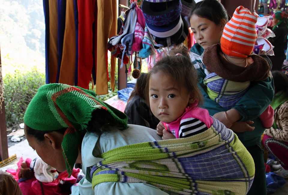 “Chen chân” ở chợ vùng biên trong kỳ nghỉ lễ - 15 Mẹ vừa địu con vừa mang hàng ra chợ bán.