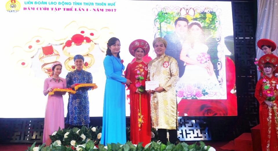 Ý nghĩa đám cưới tập thể lần đầu tiên cho công nhân khó khăn ở Huế - 12 Bà Nguyễn Khoa Hoài Hương, Chủ tịch Liên đoàn Lao động tỉnh - bà nguyệt trong Lễ đám cưới tập thể lần đầu tiên cho công nhân khó khăn Huế trao quà là cho mỗi cặp đôi là 1 cặp nhẫn 1 chỉ vàng 9999 và 1 phòng tân hôn tại Khách sạn Sông Hương.