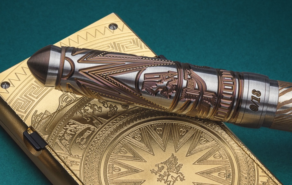 
Từ đỉnh bút là hình mặt trời lan tỏa xuống mang ý nghĩa sức mạnh và sự phồn thịnh, phía dưới là họa tiết hạc bay và các hoa văn hình học.
