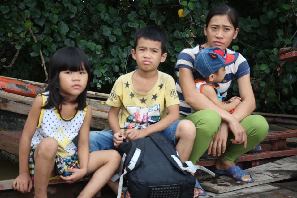 Bốn mẹ con chị Quyên đang chờ đò để sang bên kia sông tránh bão